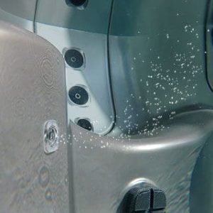 A close up of the side of a truck with water splashing on it.